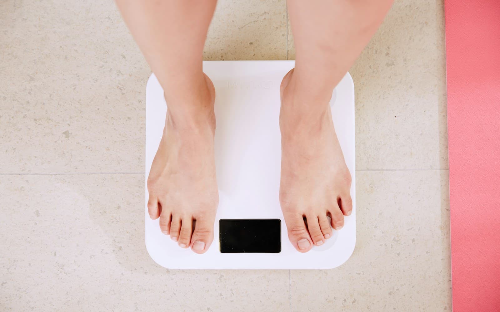 A person standing barefoot on a digital body-weight scale