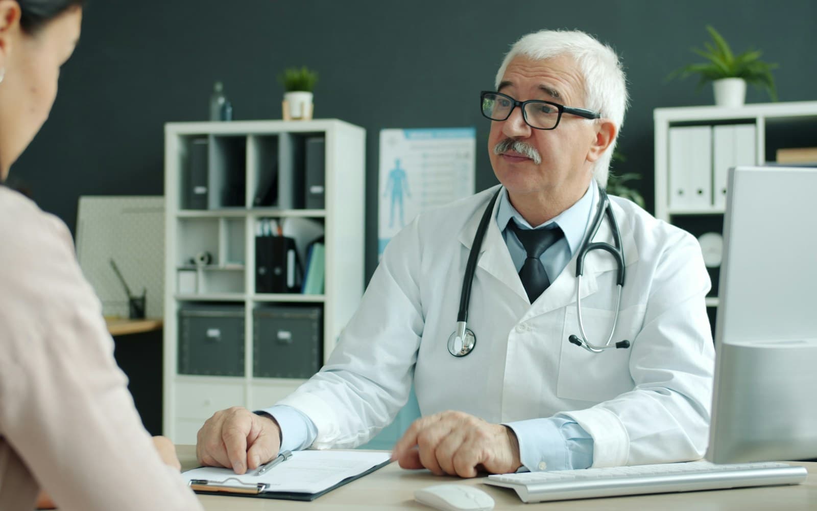 A doctor speaking with a patient during a private consultation